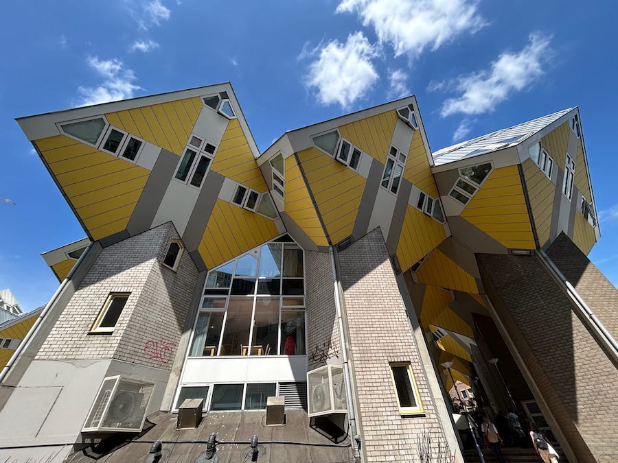 Kijk-Kubus, Rotterdam's yellow cube houses, lean over the brown brick building below.