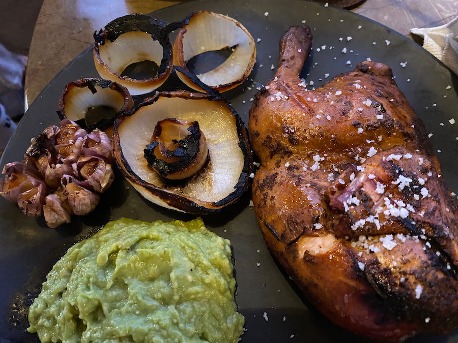 Baked garlic and onion, guacamole, and poultry served up in Holbox.