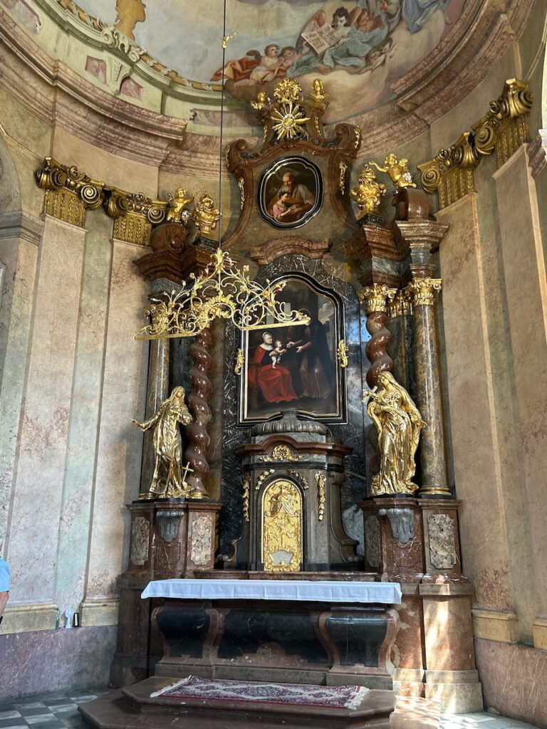 Ornate gold statues on the alter in St. Nicholas Church in Prague, Czechia.