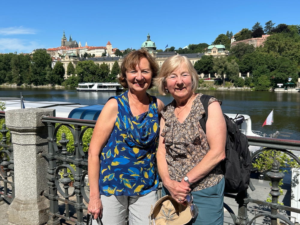Anne Webster and her sister Vera poise for a photo with Prague's Old Town in background.