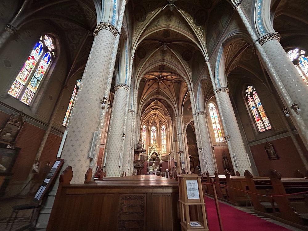 Vaulted ceilings and cool, peaceful light inside Ludmila Church in Prague, Czechia.