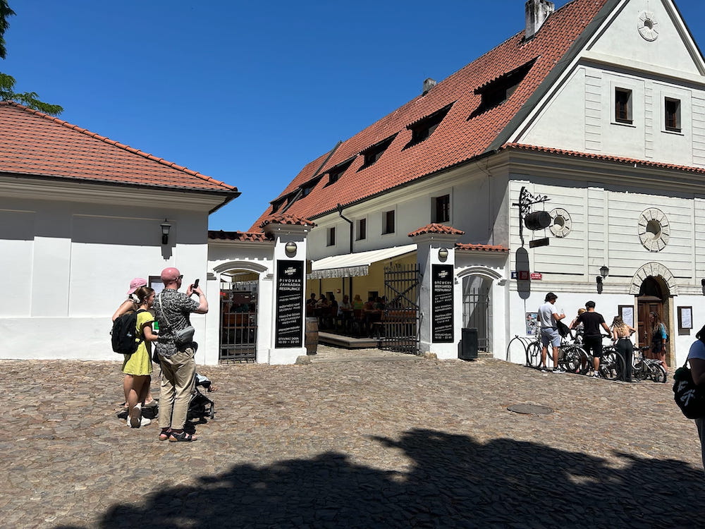 At the gates of the red roofs and white buildings of St. Norbert Brewery in Prague, Czechia.