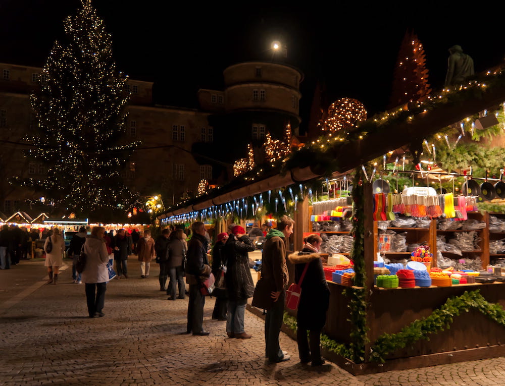 People dressed in winter wear perusing the stalls lit with festive lights at the 2010 Stuttgart Christmas Market.