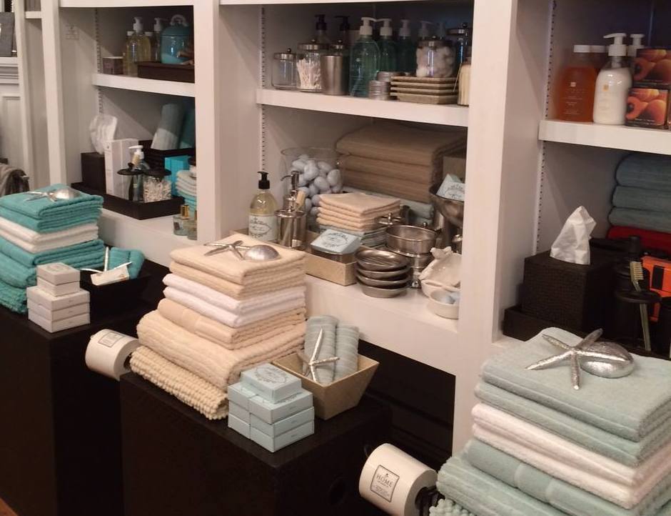 Interior of Home on water st with beautifully folded bathroom towels topped with art deco starfish, and the little robin's egg soap on the shelf.