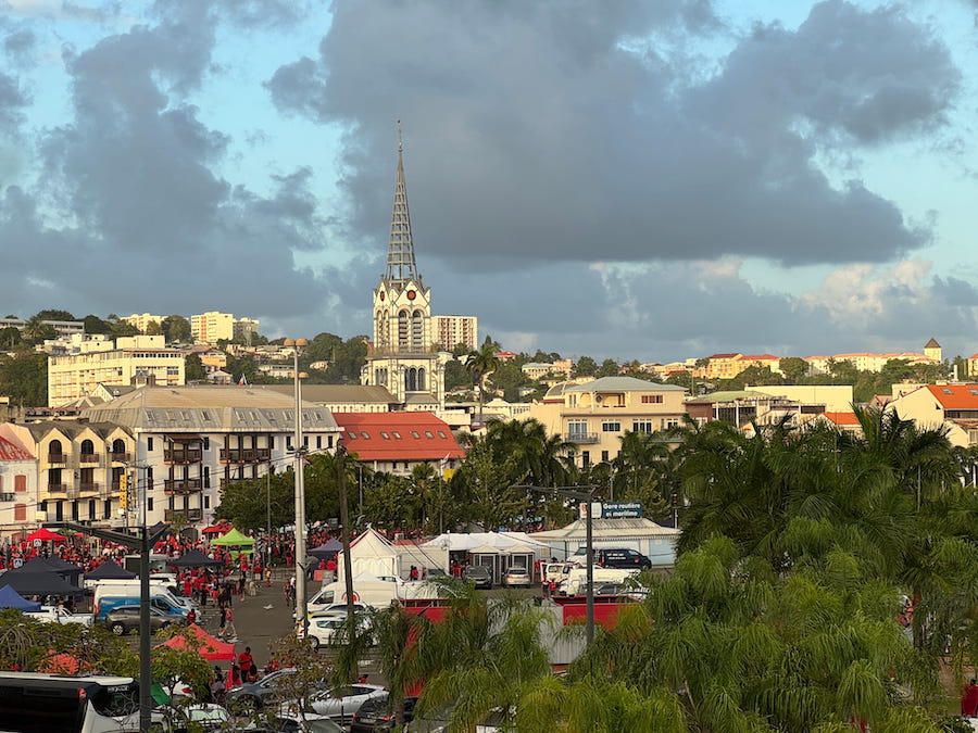 Fort-de-France during the Martinique Carnival's Red Devil's Day, with its historic architecture and streets filled with people in red.