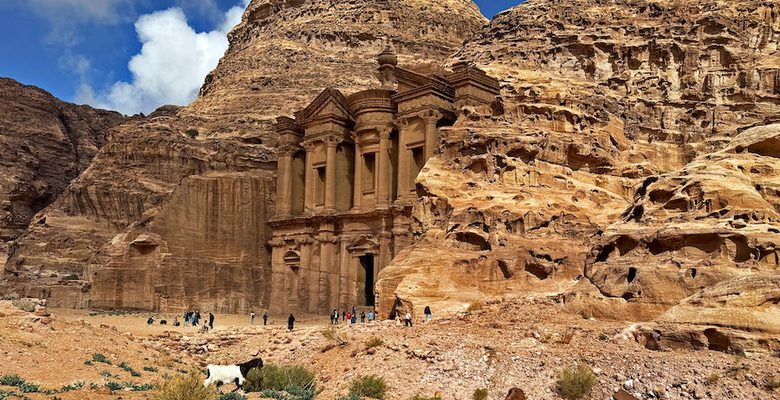 Goats, donkeys, and visitors wander around in front of Ad-Dayr.