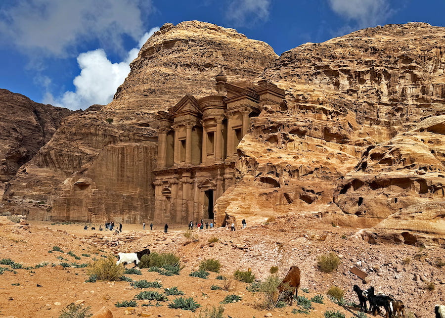 Goats, donkeys, and visitors wander around in front of Ad-Dayr.
