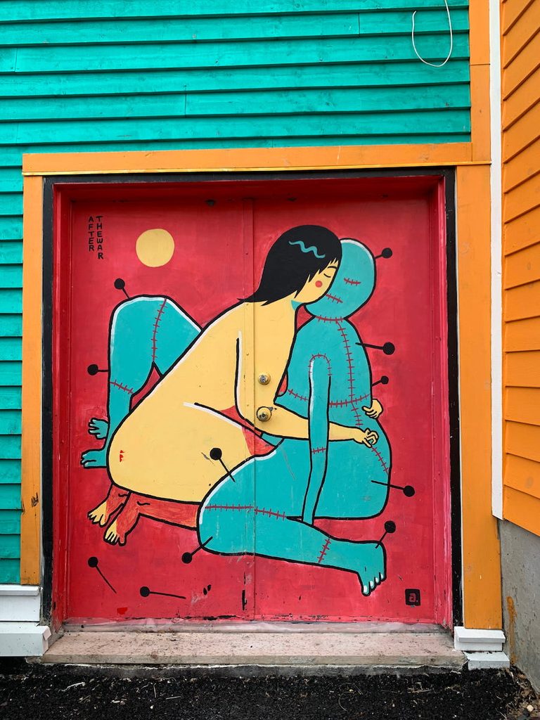 Painted door at Marigold House, featuring a naked woman and a life sized doll with pins in it.