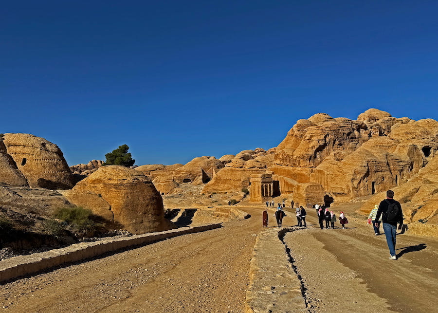 Walking from the Petra Museum toward Al Siq, the strange shapes of the desert contrast with the remains of early Nabataean buildings.