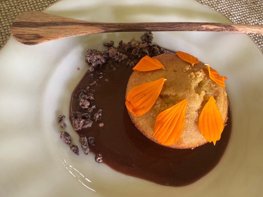 Cake with rum cacao crumble, decorated with orange flower petals - a Chef Sterelle creation.